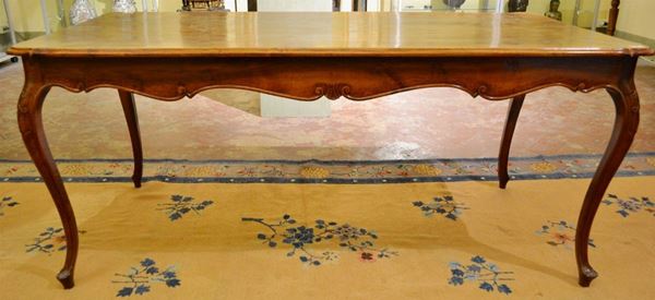 Tavolo, in stile veneto del Settecento, in noce a patina scura, piano rettangolare con bordo sagomato, fascia ondulata, gambe mosse su piedi  a ricciolo stilizzato, cm 180x85x79