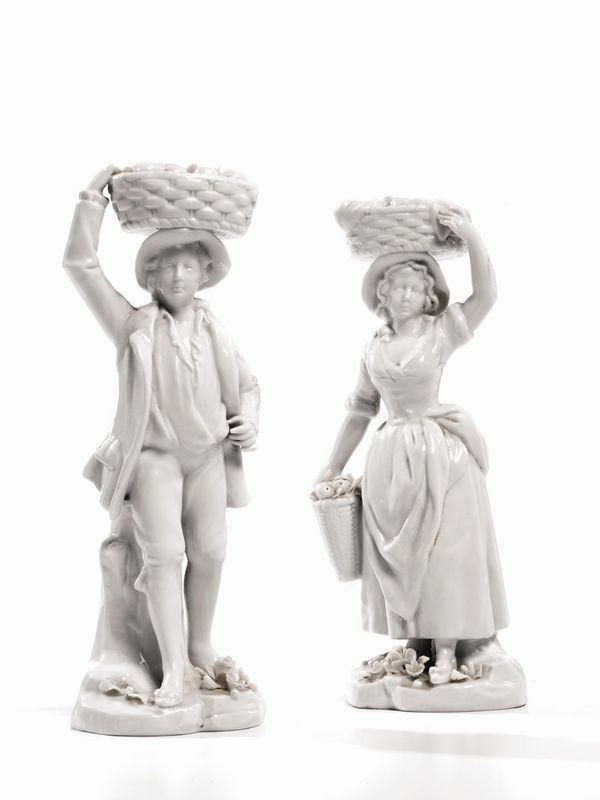 Due statuine, sec. XIX, in porcellana bianca raffiguranti contadinelli con cesti su basi a finta roccia, alt. cm 20 (2)