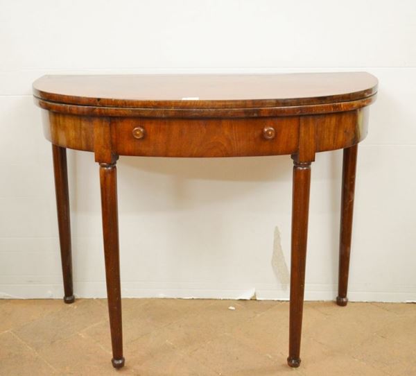 Tavolino da gioco, Toscana, inizi sec. XIX, in mogano, piano semicircolare da aprirsi a libro, fascia mossa ad un cassetto, gambe tornite, chiuso cm 96x47x74