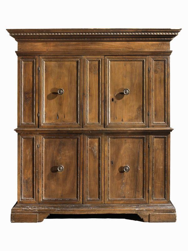 Credenza a doppio corpo, Italia Centrale, prima metÃ  sec. XVII, in noce a   patina bionda, cappello modanato con gocciolatoio a e a dadi, quattro      sportelli scorniciati con motivo a fuseruole e perline, intercalati da      lesene stilizzate, base modanata, piedi a mensola, cm 177x55x197, alcuni    restauri e sostituzioni