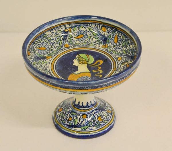 Alzata, Faenza, sec. XX, decorata a motivi vegetali e centralmente un profilo di donna, alt, cm 16,5, diam. cm 20