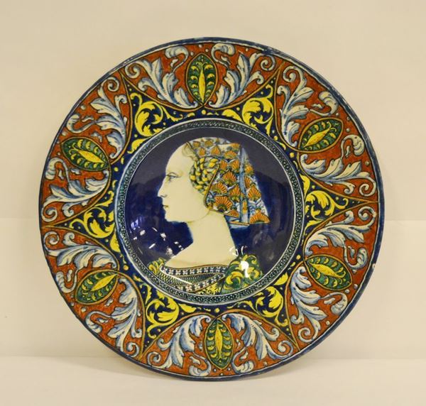 Piatto, Faenza sec. XX, in maiolica, decorato a motivi vegetali e centralmente un profilo di donna, diam. cm 43,5