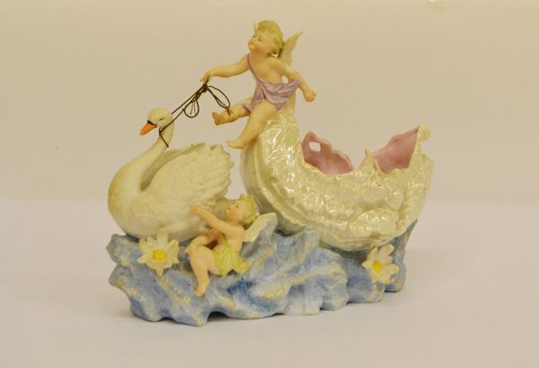 Soprammobile, sec. XX, in bisquit. raffigurante PUTTI CON CIGNO