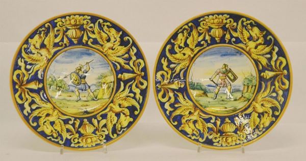 Coppia di piatti, sec. XX, in maiolica, decorati a GUERRIERI, diam. cm 27 (2)