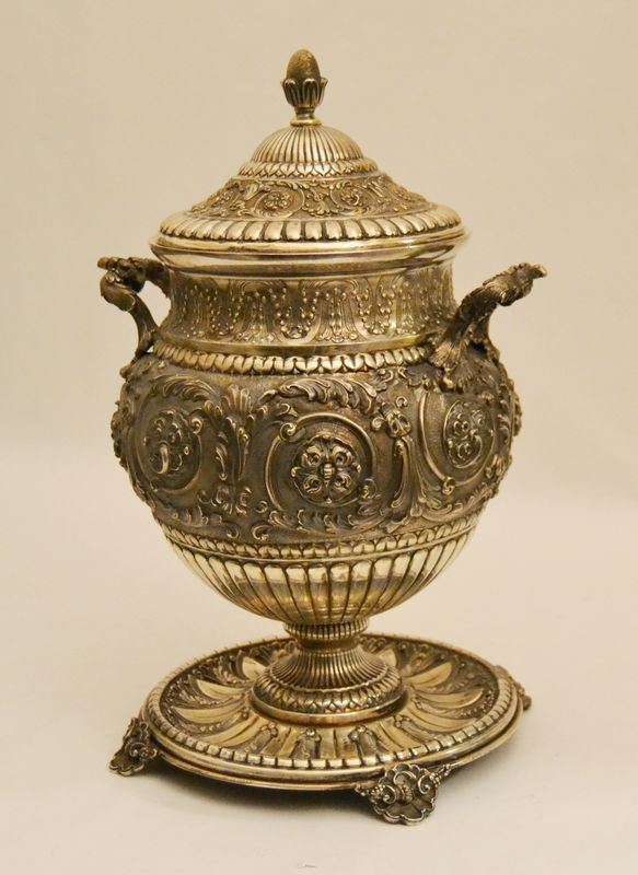 Grande coppa, in argento sbalzato e cesellato, a due manici, coperchio e base tonda poggiante su quattro piedini, alt. cm 40, gr. 2710