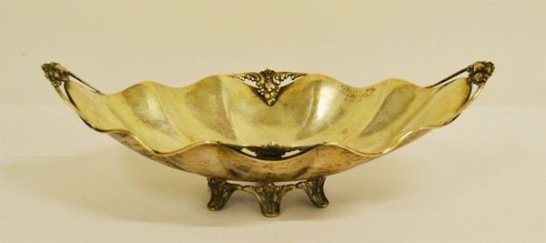 Centrotavola, sec. XX, di forma ovale, in argento, a due manici e sei piedini, cm 37x22x12, gr. 553