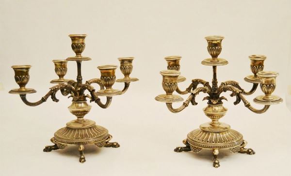 Coppia di candelieri a quattro bracci, in argento sbalzato e cesellato, con cinque portacandele, alt. cm 30, gr. 2590 (2)