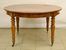 Tavolo, Inghilterra sec. XX, in noce, piano circolare allungabile, gambe tornite con finali e rotelle, diam. cm 127, alt. cm 77