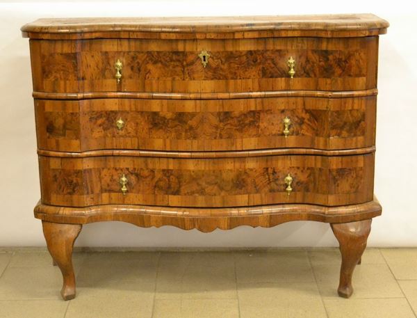 Piccolo cassettone, Ferrara metÃ  sec. XVIII, in noce e radica, piano sagomato, tre cassetti a doppia mossa, base modanata, pendaglina sagomata frontale, gambe sinuose su piedi a zoccolo stilizzato, cm 125x37x98, alcuni danni e restauri