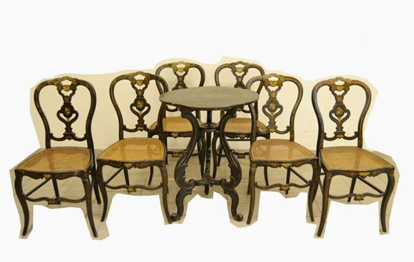 Tavolino da centro, Francia sec. XIX, in legno laccato nero, piano sagomato e decorato a motivi floreali, sostenuto da tre gambe con finali a ricciolo, cm 57x47x76, da restaurare, e sei sedie analoghe, con schienale sagomato e decorato, sedute in cannettÃ¨, difetti (7)