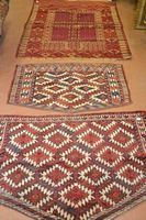 Tre piccoli tappeti, fondo rosso con decori geometrici in bianco, cm 150x117; cm 102x63 e cm 115x80