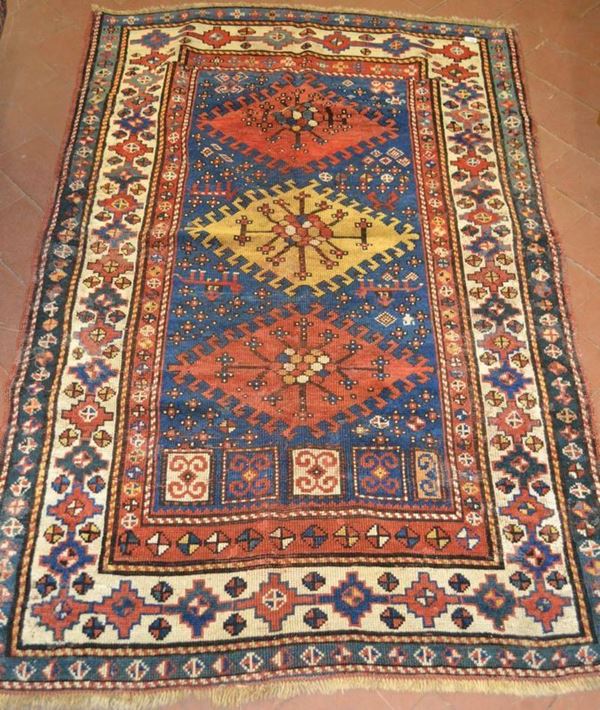 Tappeto, fondo blu , al centro tre medaglioni romboidali nei toni del senape e rosso, molteplici bordure, cm 182x113, consunto