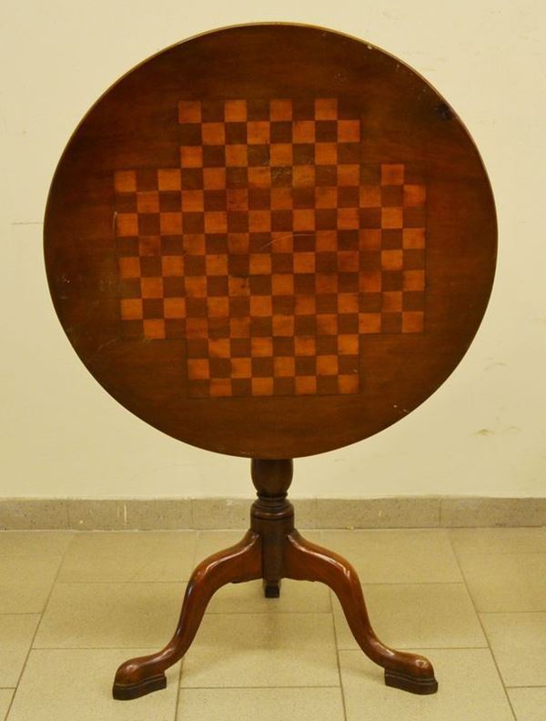 Tavolino, inizi sec. XX, in noce, con piano a vela decorata a scacchiera, gambe tornite su tre piedini sagomati, cm 76x77