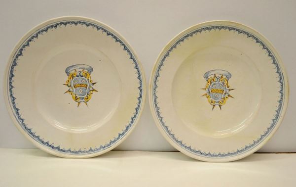 Coppia di piatti in maiolica bianca con cavetto decorato da stemma in policromia, diam. cm 41, presentano restauri