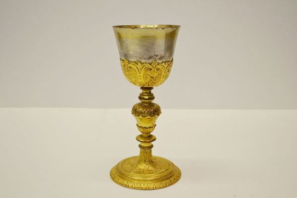 Calice in rame dorato, secolo XX, fusto con nodo piriforme decorato da foglie, piede circolare inciso e cesellato a volute, alt. cm 21,5