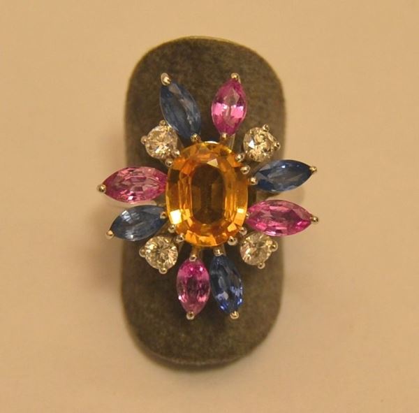 Anello in oro bianco, con montatura a fiore con quattro diamanti per ct. 0,60, e pietre di colore, ct. 5,8, peso complessivo g 8,5, marcato Torrini