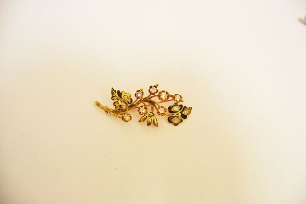 Spilla in oro giallo a basso titolo e pietre ad imitazione del diamante modellata a tralcio di fiori e foglie decorati da smalti e pietre ad imitazione del diamante, g 11, smalti danneggiati