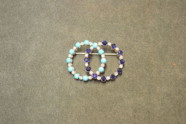 Spilla in oro bianco, turchesi, zaffiri e diamanti   modellata a doppio anello con turchesi cabochon e zaffiri rotondi alternati a brillanti, punzone 750, g 9