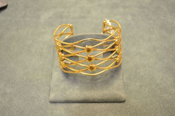 Bracciale a cerchio rigido in oro giallo, realizzato a cerchio rigido aperto e traforato, decorato con piccole stelle, g 33