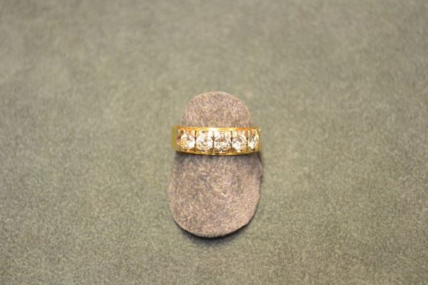 Anello veretta in oro giallo e diamanti realizzato come una fascia d'oro impreziosita da cinque brillanti rotondi di ct  complessivi 0.80 circa, punzone 750 e 103, g 7