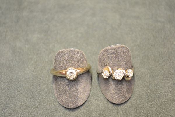 Due anelli in oro bianco e diamanti un solitario con brillante rotondo montato entro castone, ct 0.45 circa, punzone 750; un anello decorato da tre fiorellini in pave di diamanti, punzone 750, g 10 complessivi (2)