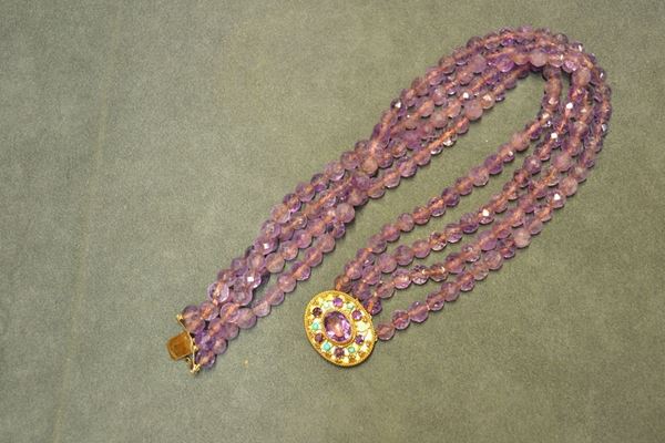 Collana in oro rosa, ametista e pasta di turchese realizzata a quattro fili di sfere sfaccettate di ametista, con fermatura di forma ovale decorata da un'ametista centrale ovale e piccoli cabochon di pasta di turchese, g 160