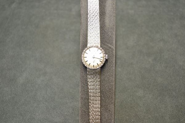 Orologio per signora Zenith, anni '60, in oro bianco 18 Kt e diamanti, cassa con fondello a scatto, lunetta decorata da una linea di brillanti. Quadrante argente' con indici applicati e lancette a bastone, secondi ad ore 6. Movimento a carica manuale. Bracciale in oro bianco a maglie satinate. Diam. mm 23