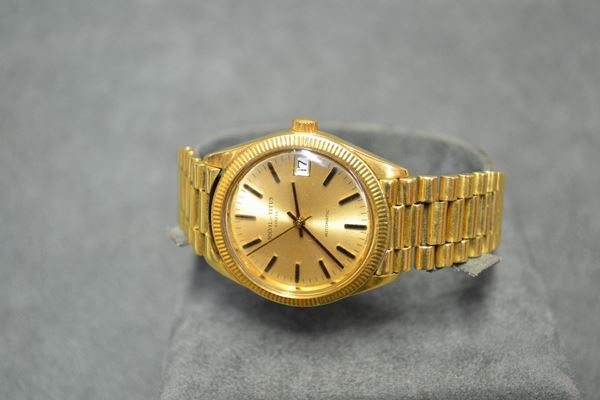 Orologio da polso Solvil et Titus Geneve, in oro giallo 18 kt Cassa in tre corpi con fondello e corona a vite, lunetta zigrinata, vetro plastica. Quadrante champagne con indici applicati a e lancette a bastone, datario ad ore 3. Movimento a carica automatica. Bracciale a maglie in oro giallo, chiusura deployante. Diam. mm 33