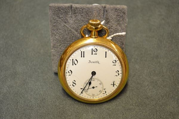 Orologio da tasca Zenith, inzio sec. XX, in oro giallo 18 kt Cassa in oro liscio, corona di carica ad ore 12. Quadrante bianco con numeri arabi, lancette ad ago e piriforme, secondi ad ore 6. Movimento a carica manuale. Diam. mm 48,5
