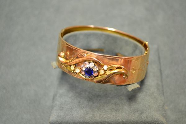 Bracciale, fine sec. XIX, in oro a basso titolo, madreperle e vetri realizzato come una fascia incisa a motivi geometrici e decorata al centro da volute e corolle in vetri e madreperle applicate, g 19