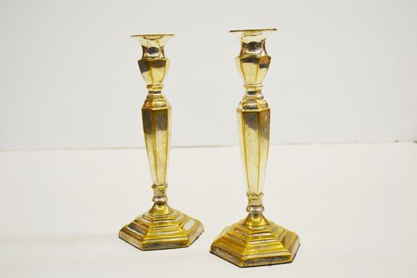 Coppia di candelieri in metallo argentato                                poggianti su base geometriche, alt. cm 25