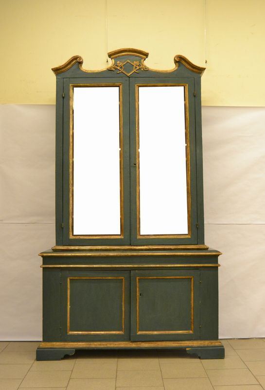 Libreria, sec. XVIII, in legno laccato verde oro, a due corpi, quattro sportelli, due dei quali in vetro, cm 133x32x233, restauri