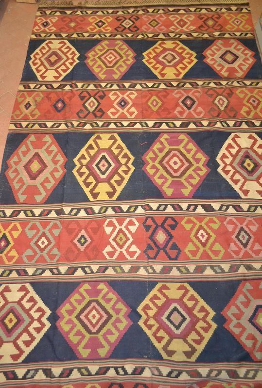 Grande tappeto, fondo blu decorato da medaglioni nei toni del rosso, senape e bianco, cm 375x212, consunto