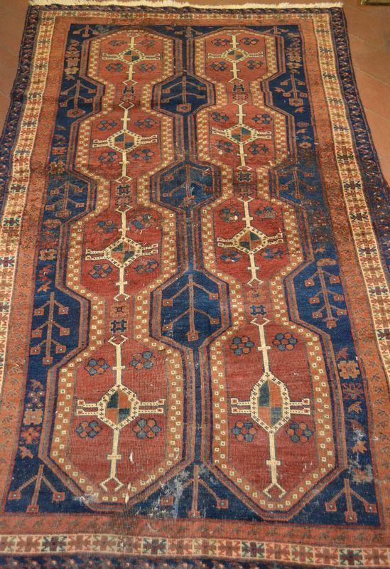 Tappeto fondo blu decorato da due linee di medaglioni rossi, molteplici bordure, cm 195x118, consunto