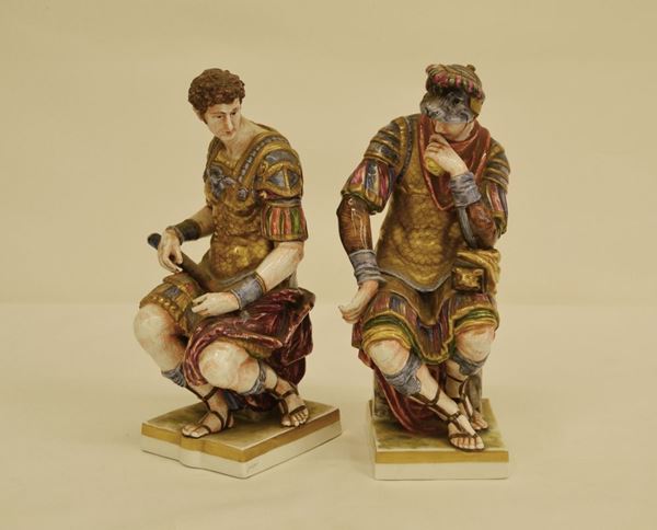 Due sculture, sec. XX, in porcellana, GUERRIERI ROMANI, alt. cm 25 ( 2 )