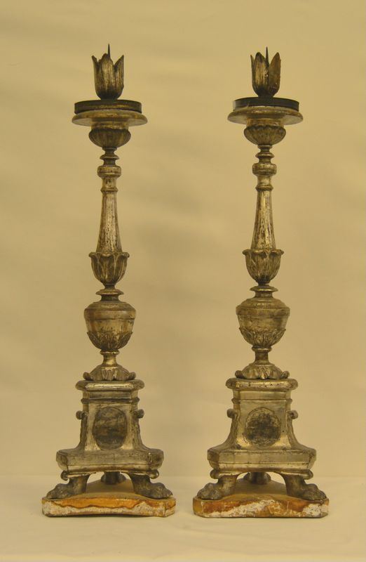 Coppia di candelieri, sec. XVIII, in legno laccato argento, fusto centrale tornito e intagliato a motivi vegetali, piedi a zampa felina, alt. cm 96 ( 2 )