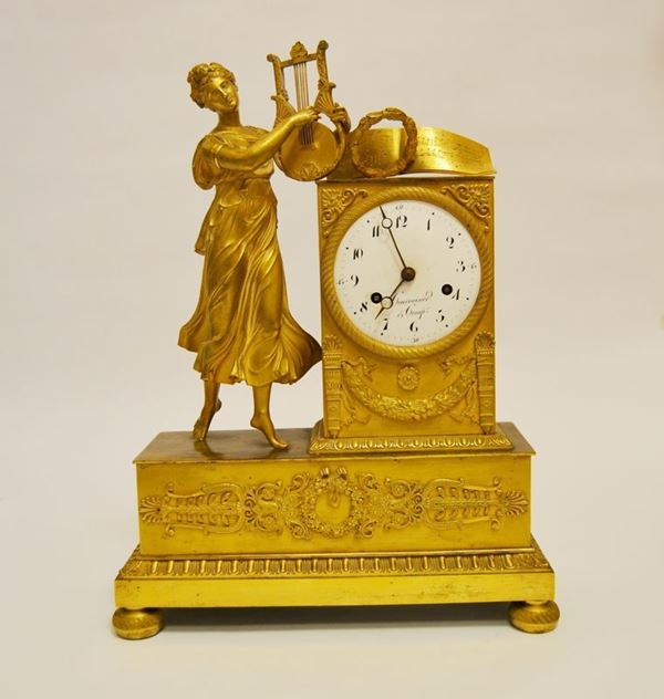 Orologio soprammobile da tavolo, inizi sec. XX, in bronzo dorato, con figura di donna che suona la cetra, decorazioni a festoni e ghirlande, quadrante marcato COURVOISIER e COMP., alt. cm 38, difetti e mancanze