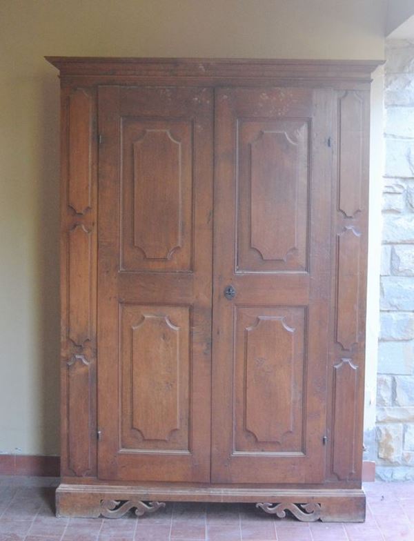 Armadio, sec. XIX, in noce, a due sportelli sformellati, cm 133x41x200