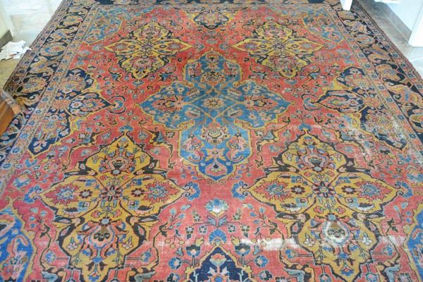 Tappeto persiano, sec. XIX, fondo rosso-blu a motivi floreali, cm. 350x280, consunto
