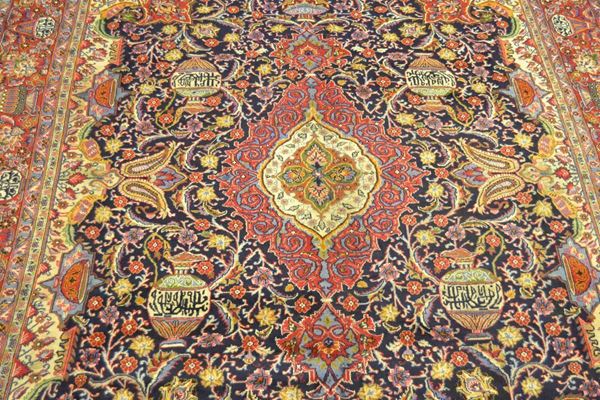 Tappeto persiano KASHMAR firmato, fondo blu, campo a motivo e reperti archeologici molticolore, bordura rossa, celeste e beige, cm 390x290