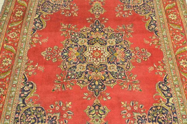 Tappeto persiano TABRIZ, di vecchia manifattura, fondo in tinta unita rosso, con medaglione centrale e bordura a motivo floreale multicolore, cm 395x290