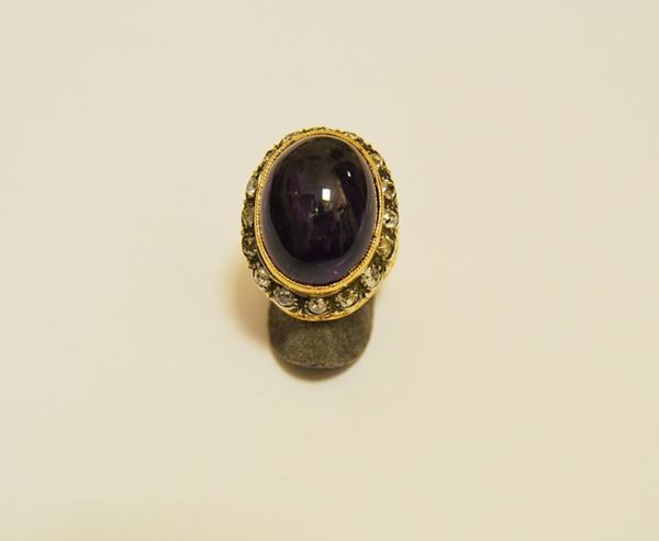 Anello in oro giallo a fascia traforata con ametista, cabochon con contorno di brillanti, gr 13,5