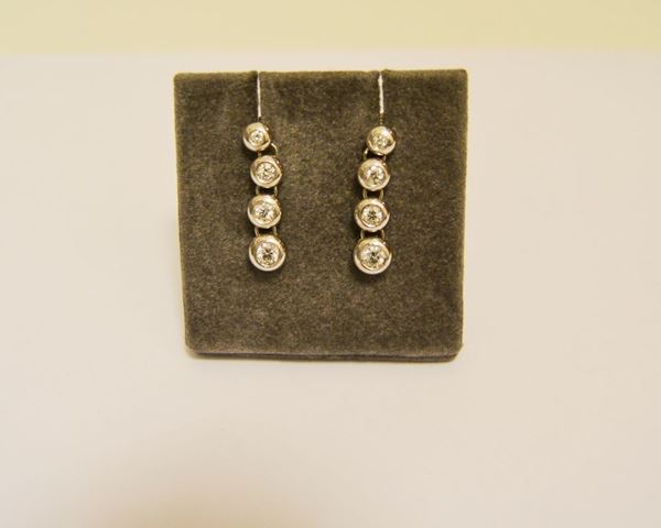 Paio di orecchini in oro bianco con pendente decorato a 4 brillanti  di varie misure, gr 7,5
