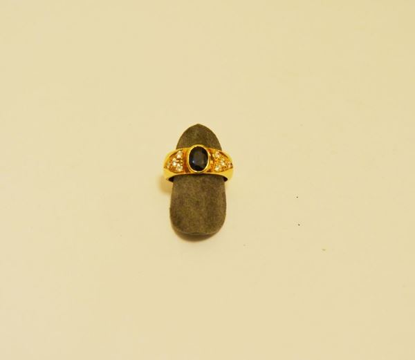 Anello in oro giallo con zaffiro ovale e brillanti laterali, gr 7