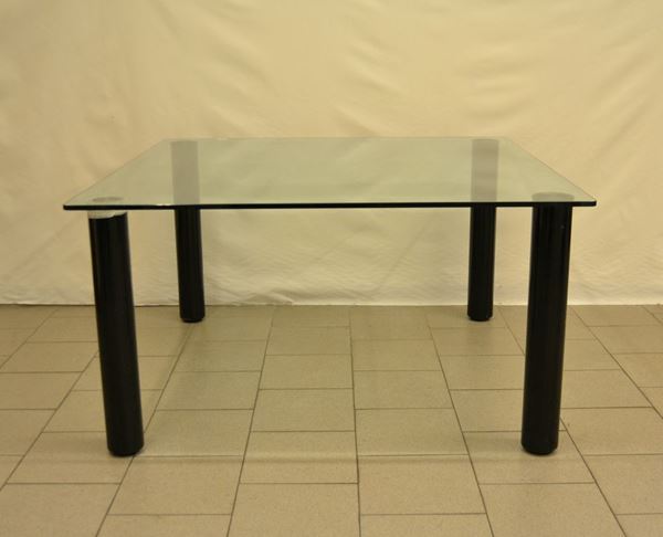 Tavolo, sec. XXI, piano quadrato in cristallo, quattro gambe circolari, cm 130x130x70