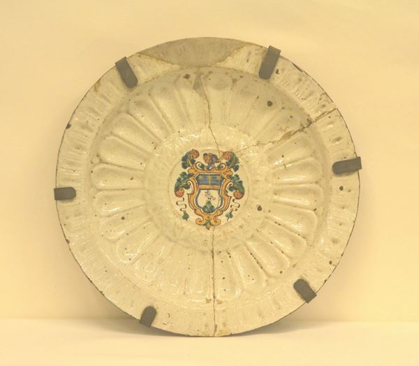 Piatto da parete, sec. XVIII, in maiolica, al centro decorato con STEMMA, diam. cm 44, rotture e mancanze