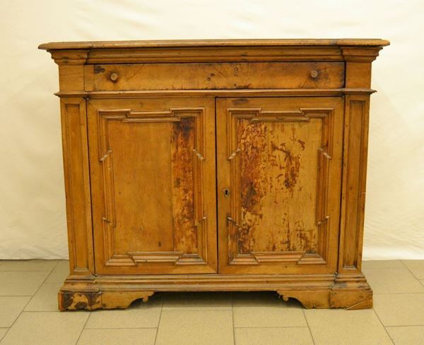 Credenza, in noce sagomato, ad un cassetto e due sportelli, piano a becco di civetta, piedi a mensola, cm 136x45x113, ricostruita con materiale antico, difetti