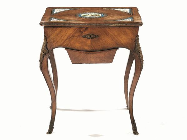 Tavolino da lavoro, Francia, sec. XIX, in noce decorato con placche in      porcellana di SÃ¨ a decoro animalistico e floreale entro cornici in bronzo,  piano rettangolare con angoli lobati, apribile, pendaglina sagomata         frontale e laterale, cassetto pensile sottostante, gambe sinuose con        scarpette in bronzo, cm 61x42x75, alcuni danni