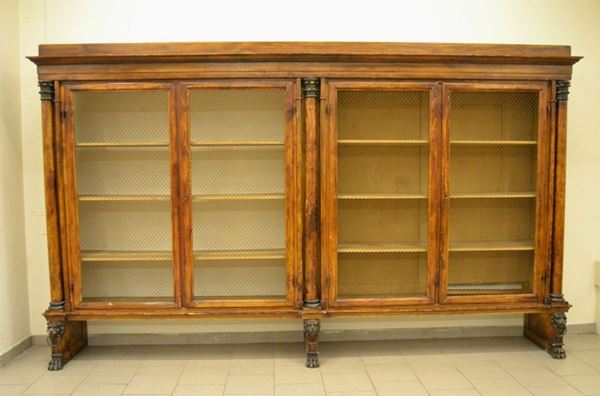 Libreria, Toscana, sec. XIX, in pioppo, a quattro sportelli con grate in ferro, tre colonne con finali a capitello, tre basi con teste di leoni e finali a zampa felina, cm 351x54x213, mancanze