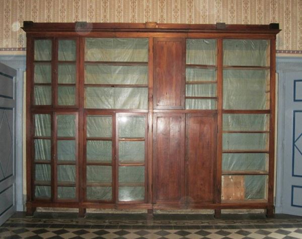Grande libreria, Toscana, sec. XIX, in noce, a sedici sportelli di cui otto in vetro, cm 410x310, mancante dei fondi